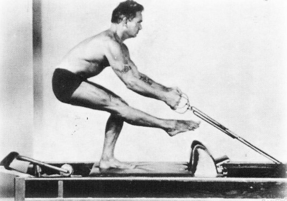 Joseph Pilates esegue un esercizio classico sul Reformer — il macchinario simbolo del metodo
