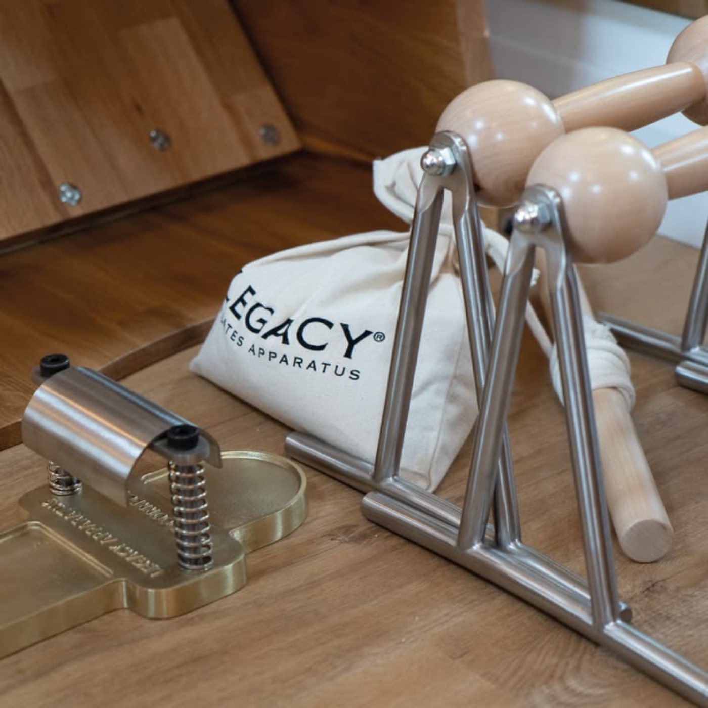 Foot Corrector originale di Joseph Pilates e attrezzi della linea Legacy Apparatus su pavimento in legno